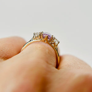 The side profile of a purple and lilac sapphire engagement ring showing the setting and how it sits on a finger beautifully.