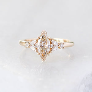 Yellow gold ring with a champagne marquise cut diamond and white diamond clusters, front view