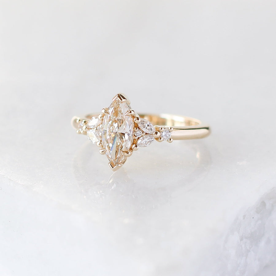 Yellow gold ring with a champagne marquise cut diamond and white diamond clusters, front view