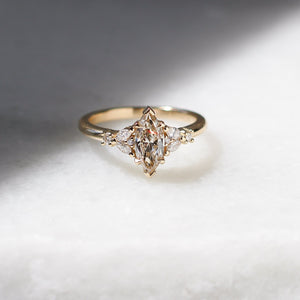 Yellow gold ring with a champagne marquise cut diamond and white diamond clusters, front view