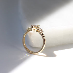 Yellow gold ring with a champagne marquise cut diamond and white diamond clusters, side view