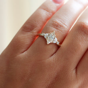 Yellow gold ring with a champagne marquise cut diamond and white diamond clusters, on hand