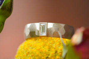 custom sculptural wedding ring in 14k gold with diamond baguette