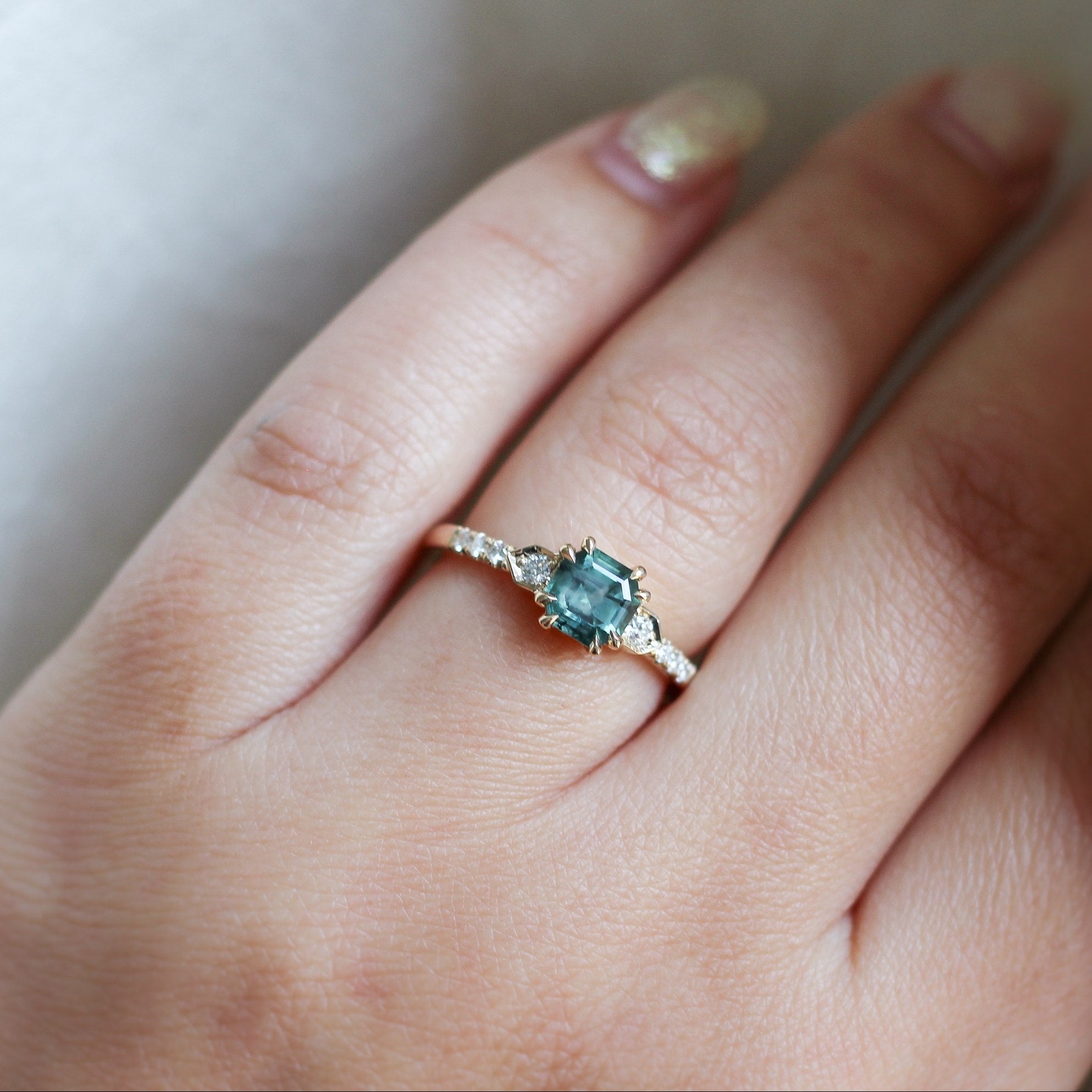 Cut Corner Rectangle Step Cut Greeen Sapphire Ring on hand in sunlight
