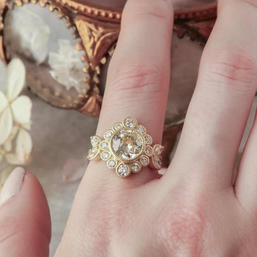 Natural diamond marquise leaves and a graduated diamond halo set in reclaimed 18 karat yellow gold around an antique old European cut diamond. Ready to ship antique inspired flower engagement ring, size 6. 
