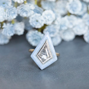 2.39 Kite Rosecut Diamond and Blue Agate Gemstone Halo Ring in Two Tone Gold on table in front of white and light blue flowers