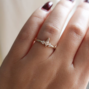 Champagne kite cut diamond ring with white diamond accents, on hand