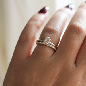 yellow gold diamond solitaire ring with straight pavee diamond band on hand