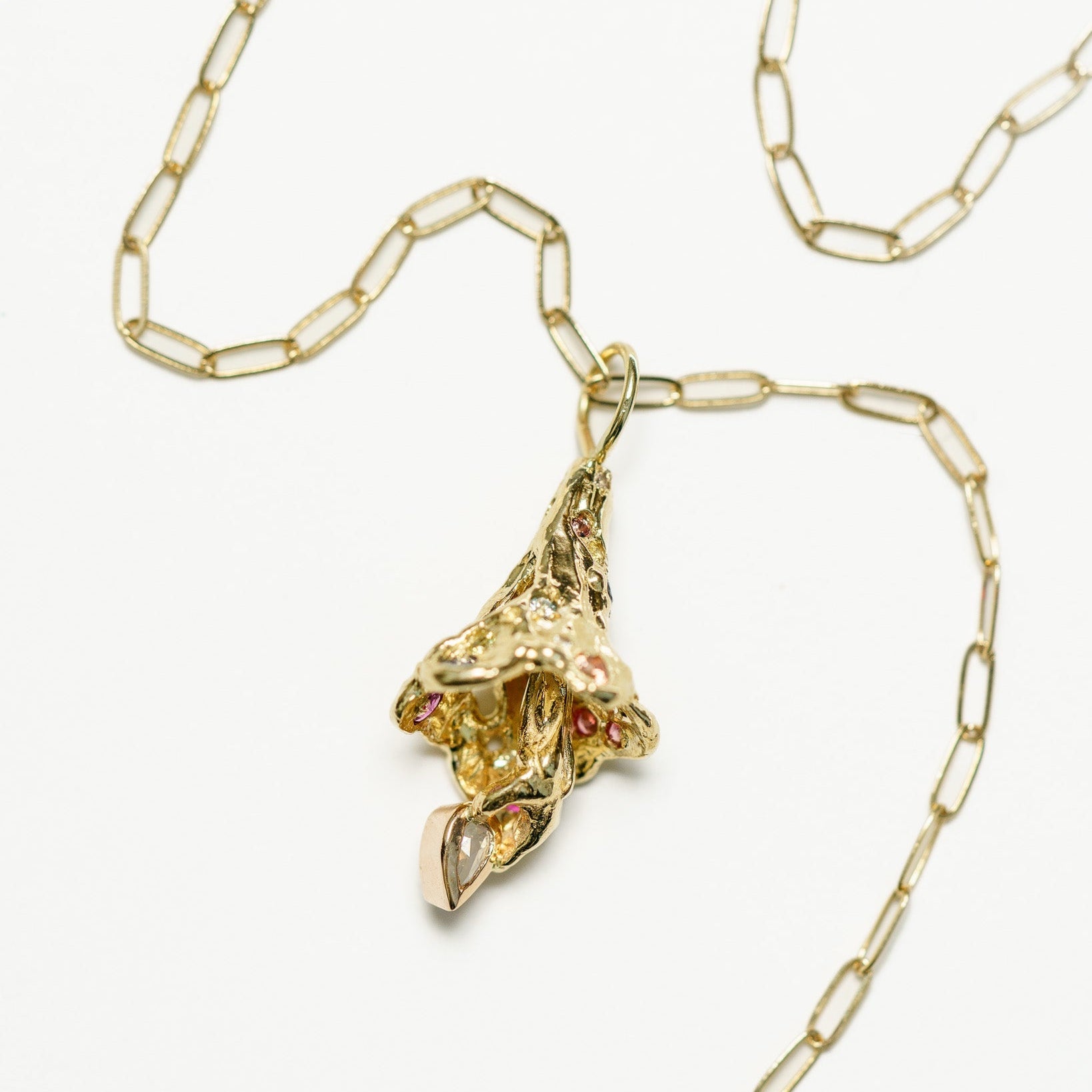 Fairy Bell Charm with colorful sapphires and a pear diamond on a yellow gold chain